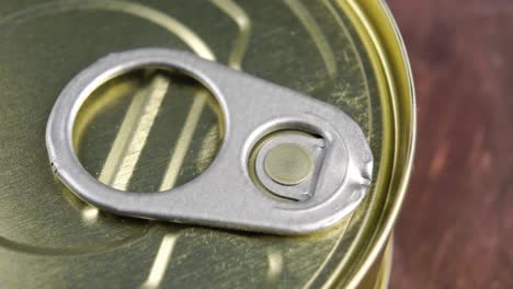 conserved food aluminium can with pull ring on a wooden background. unopened hermetic container. macro