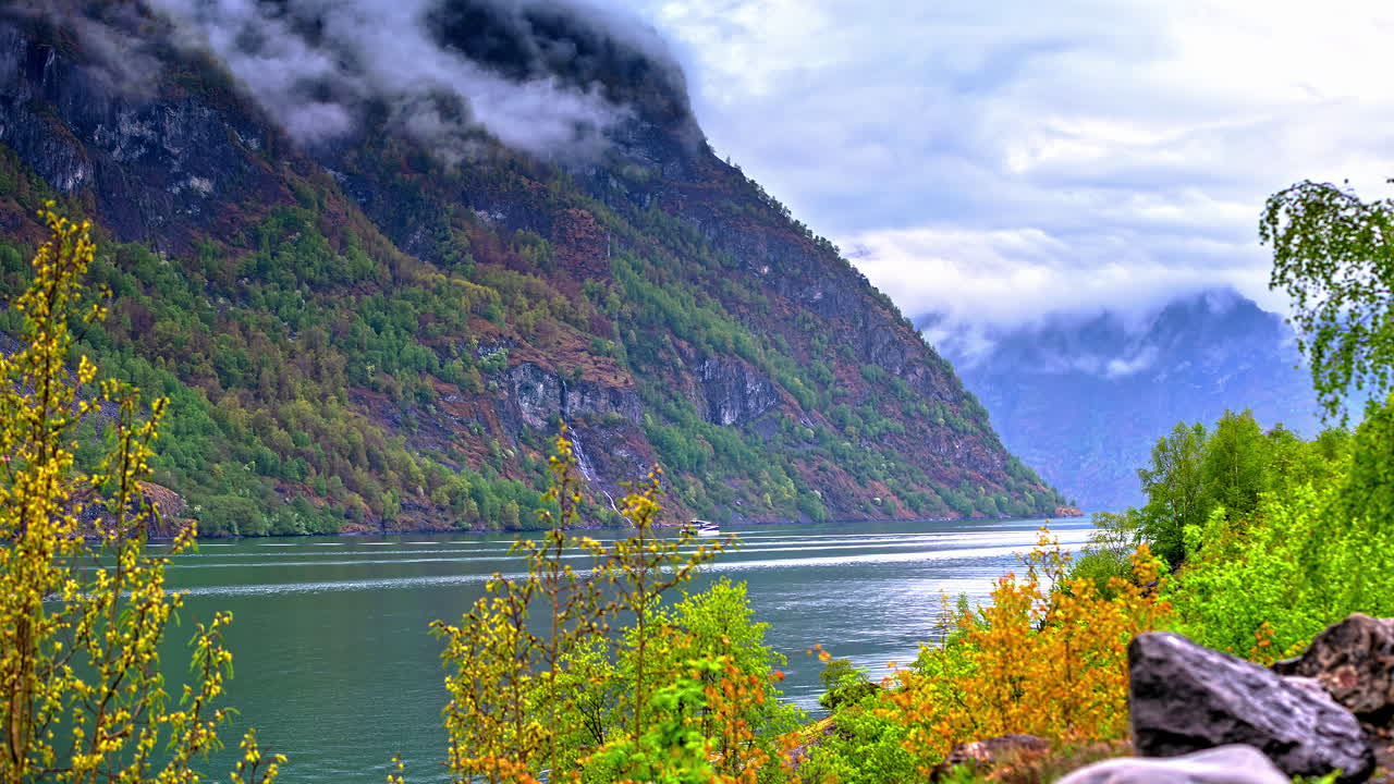 여름철 노르웨이 피요르드에서 거대한 msc 유람선의 타임랩스 샷으로 낮에는 산악 지형이 곳곳에 있습니다.