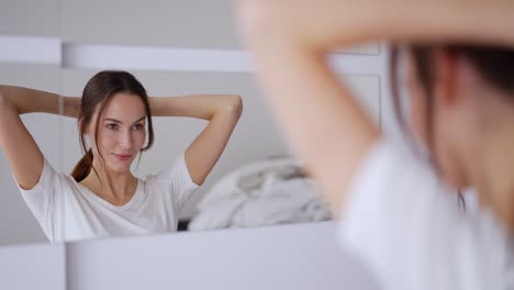 woman styling her hair in front of a mirror