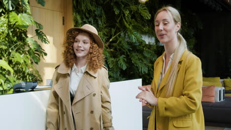 redheaded female guest and blonde receptionist in a hotel