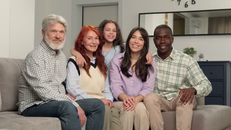 retrato de una feliz familia multiétnica de diferentes generaciones de edad en casa en el sofá