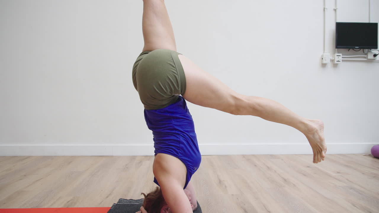 Athletic Woman Performing Headstand Yoga Pose on Mat