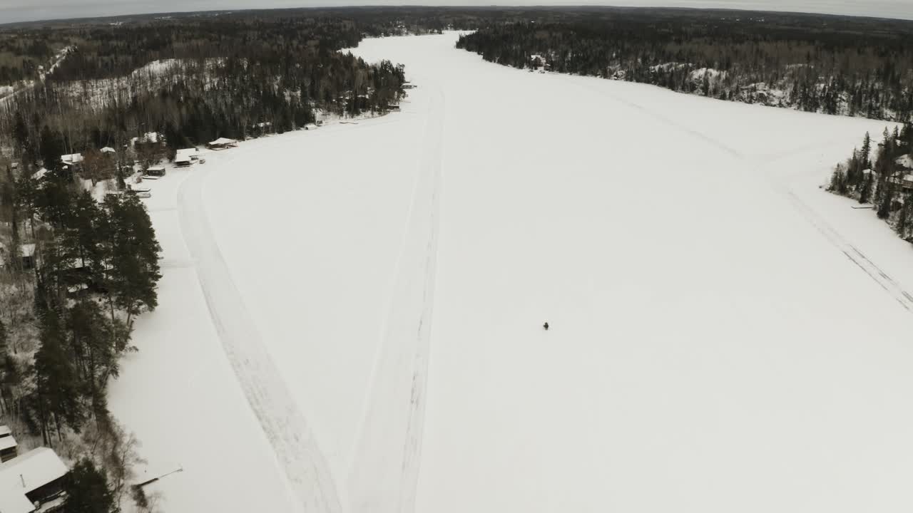 снегоход едет по замерзшему озеру в арктической части канады