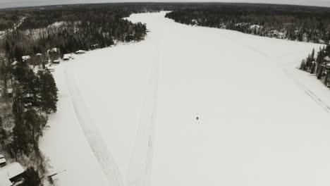 A-snowmobile-travels-along-a-frozen-lake-in-the-arctic-of-Canada