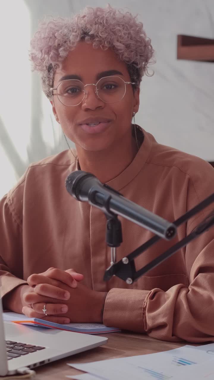 Young african american woman radio announcer reads latest news into microphone