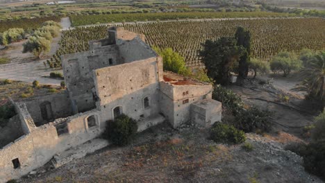 Reveal-shot-of-old-abandoned-farm-at-Sicily-Italy,-aerial