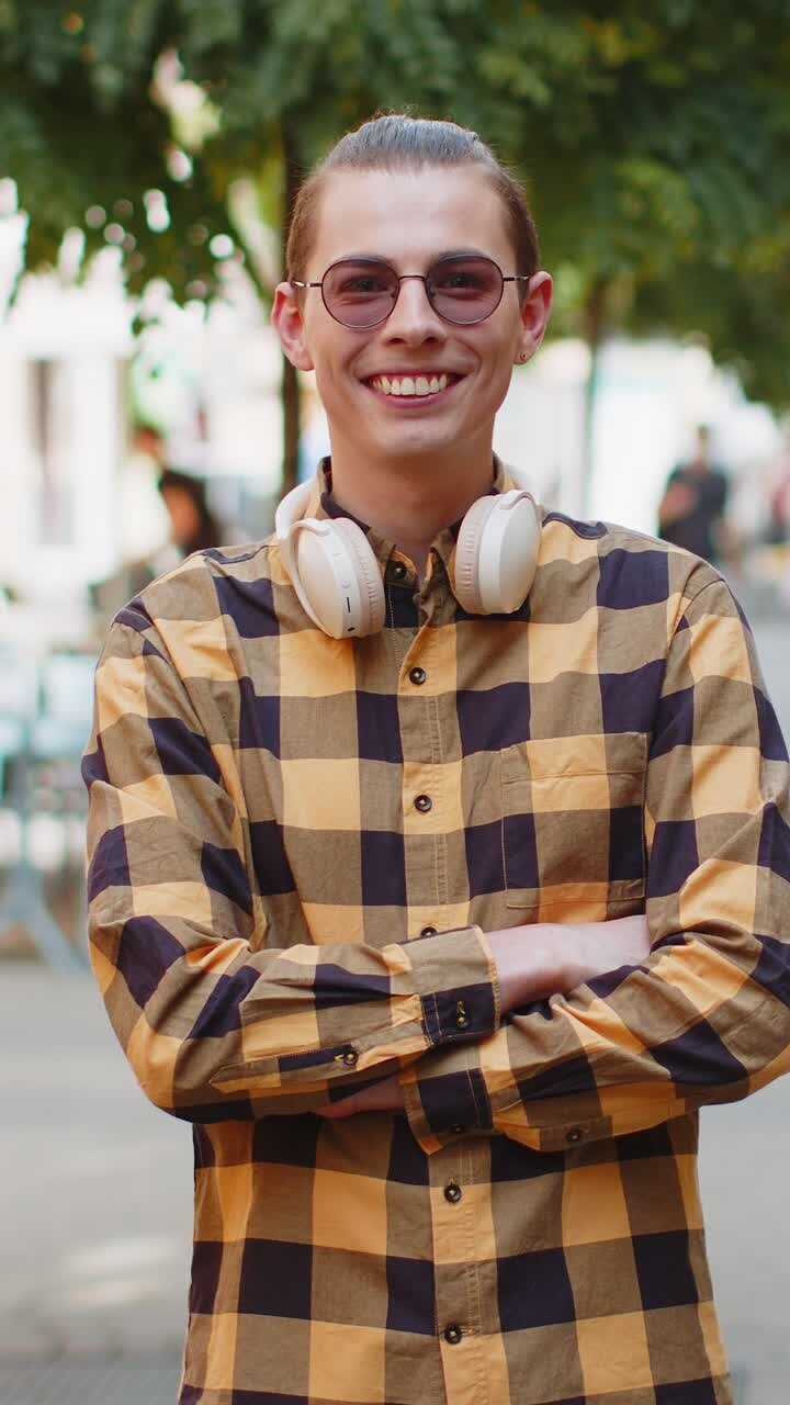 Ritratto di un uomo felice che sta in piedi di spalle, si volta sorridendo con espressione felice e guarda la fotocamera