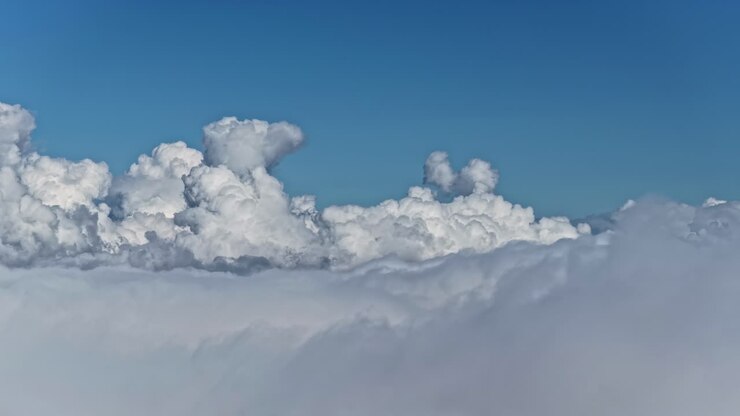 Fluffy clouds under clear blue sky create a peaceful serenity