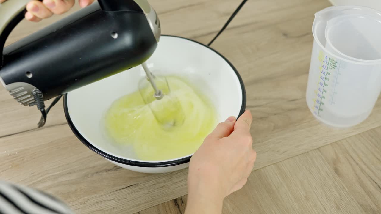 Electric mixer begins whipping egg whites, the first step in creating airy tiramisu cream.