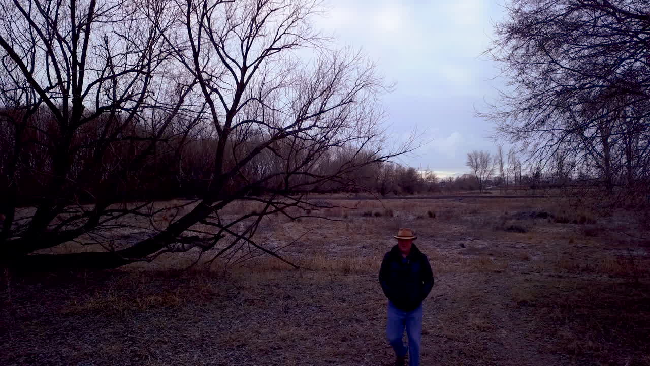 한 남자가 우울한 숲 속으로 들어간다