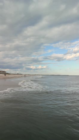 Aerial drone video of a close up of the shoreline and waves from the ocean.