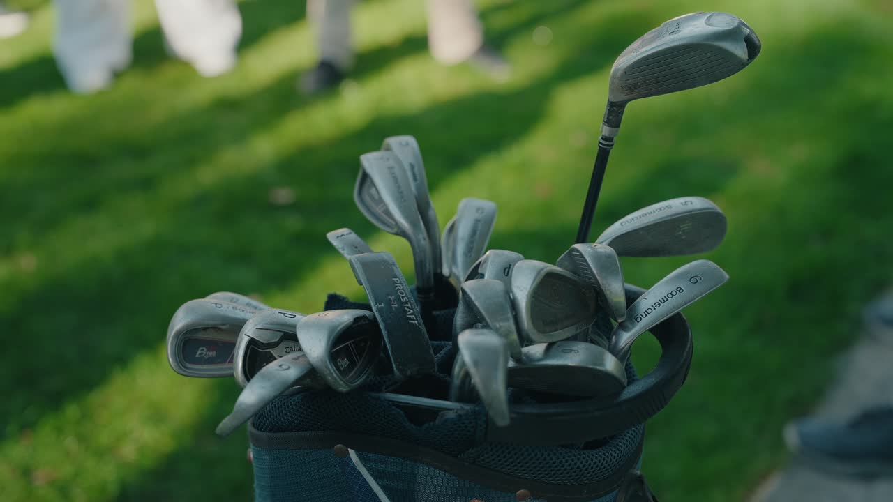 Close de tacos de golfe guardados em uma bolsa na grama