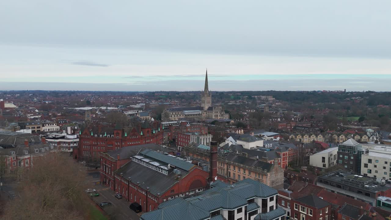 Norwich cityscape with church spire, turrets, streets, and shops, aerial view