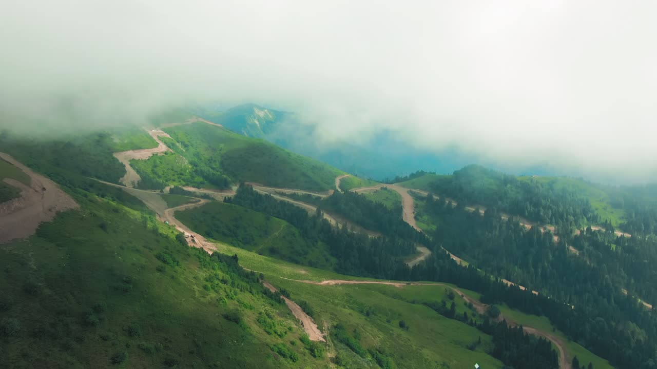 paisaje montañoso con carreteras sinuosas y niebla