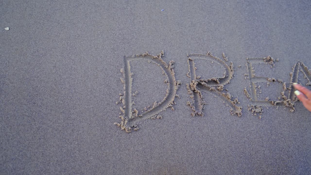 Word written on the beach. Dream written on beach sand background