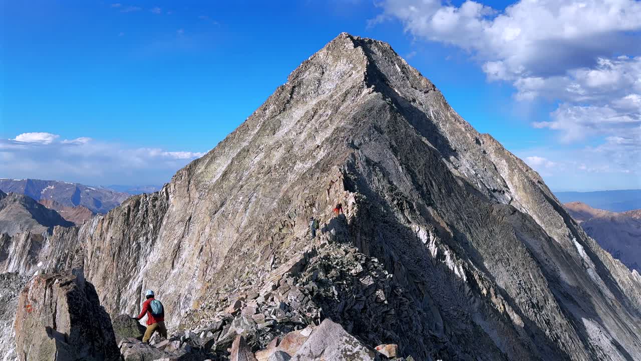 Towering prominent Rocky Mountains Capitol Peak hiking climbing Knifes Edge North East Ridge Trail scrambling Colorado fourtneer rugged terrain summer blue sky morning sunny rugged terrain static shot