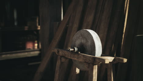 a vintage sharpening stone on a wooden stand in a rustic workshop