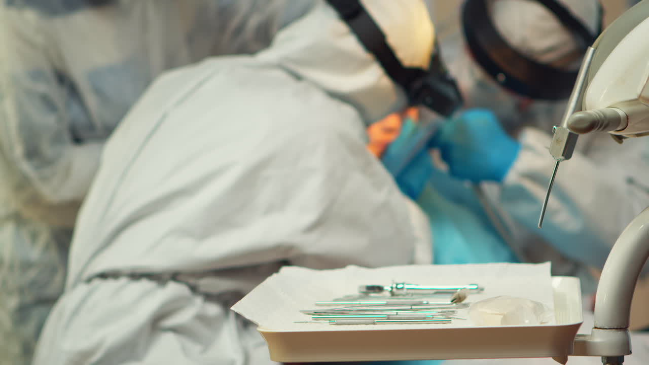 equipo médico que trabaja con herramientas esterilizadas usando un escudo facial,