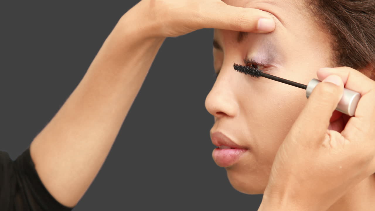 artista de maquillaje poniendo máscara en la cara de las modelos