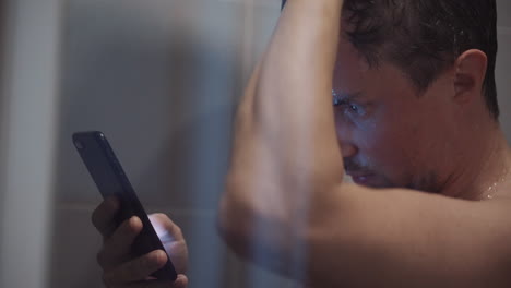 hombre usando el teléfono en la ducha