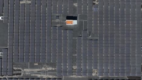aerial top down shot of solar panels on large building of shopping mall