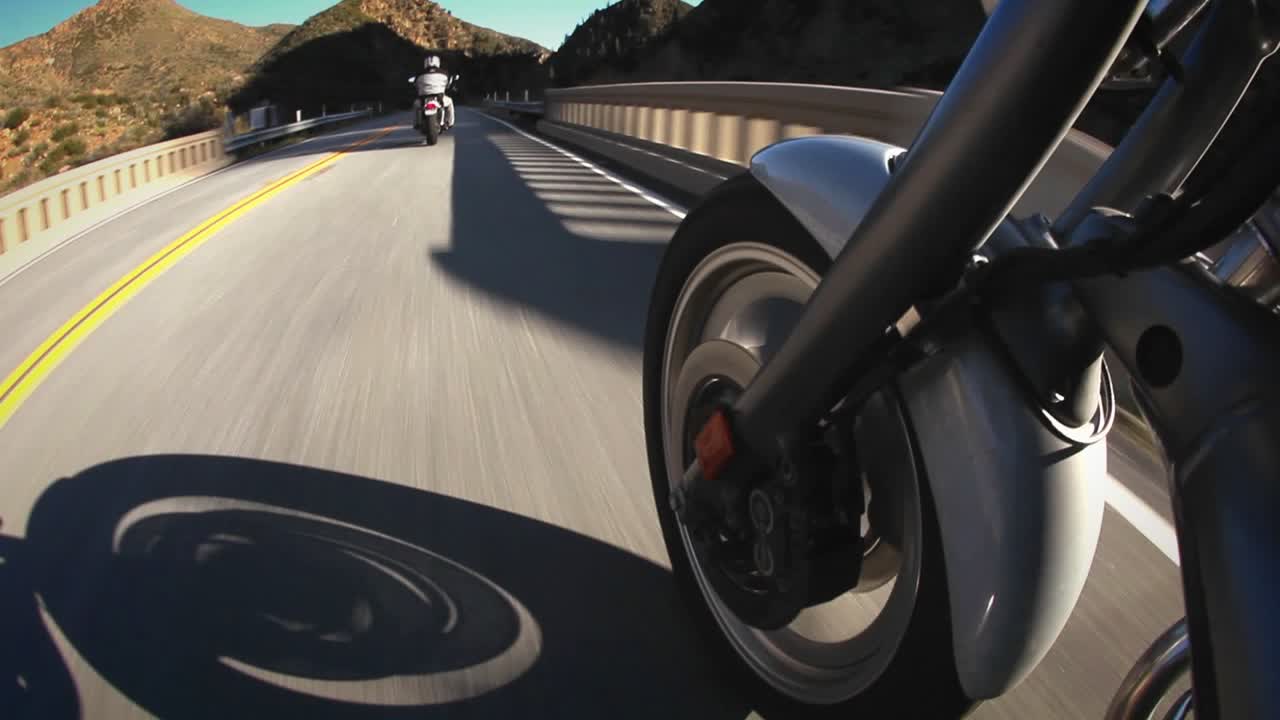los motociclistas viajan por una carretera de montaña