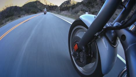 motorcyclists ride down a mountain highway