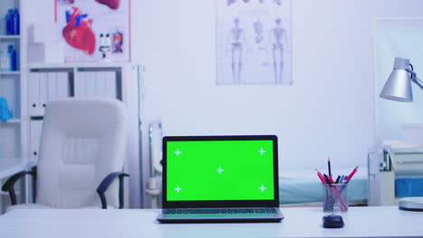 portátil en el gabinete del hospital con pantalla verde