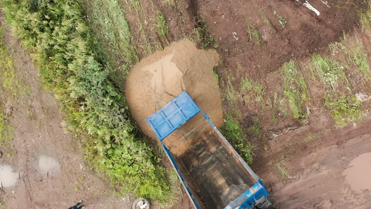 camión de descarga cargando arena en el sitio de construcción