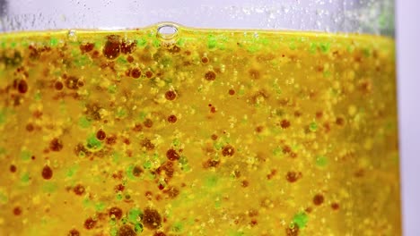 vibrant chemical reaction with colorful droplets in a beaker, showcasing density and separation in a laboratory setting