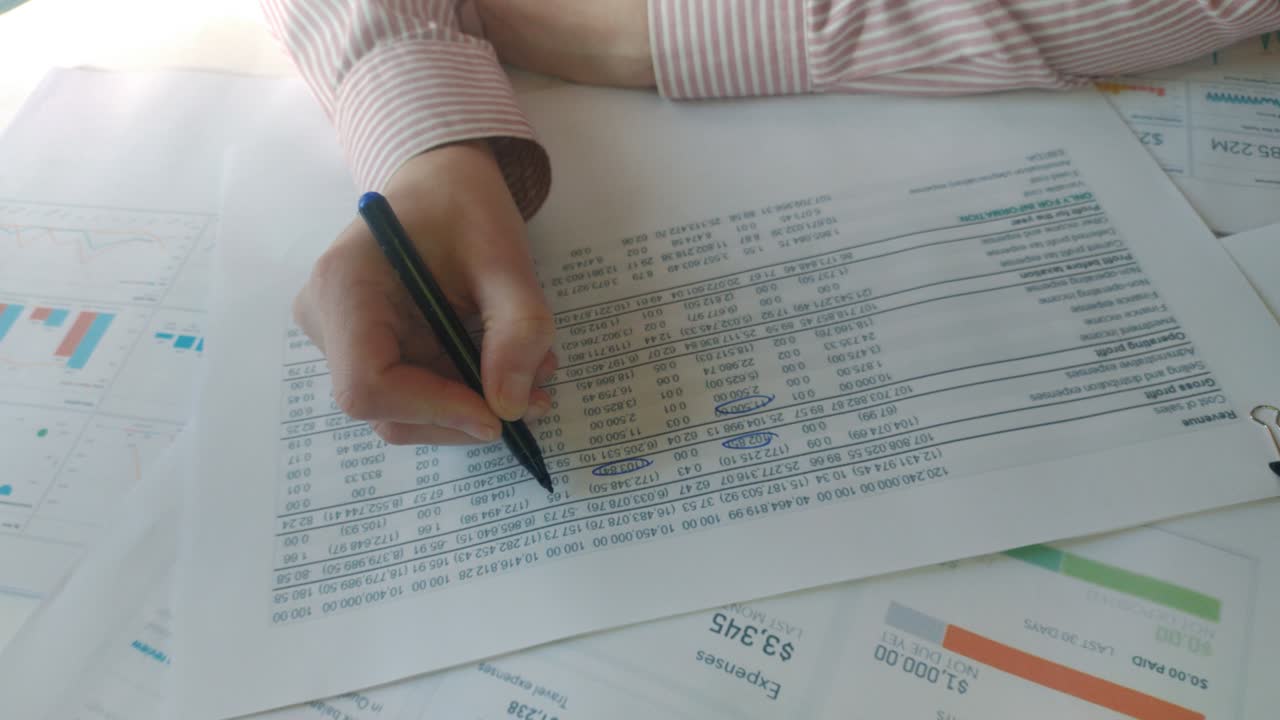 감사원의 손은 보고서에 있는 재정적 숫자를 확인합니다.