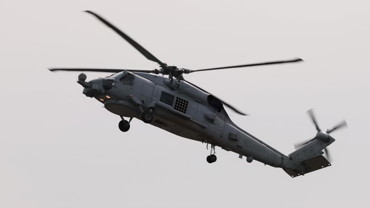 A helicopter performs dynamic aerial maneuvers against a cloudy sky at the Avalon Airshow in Geelong, showcasing agility and precision