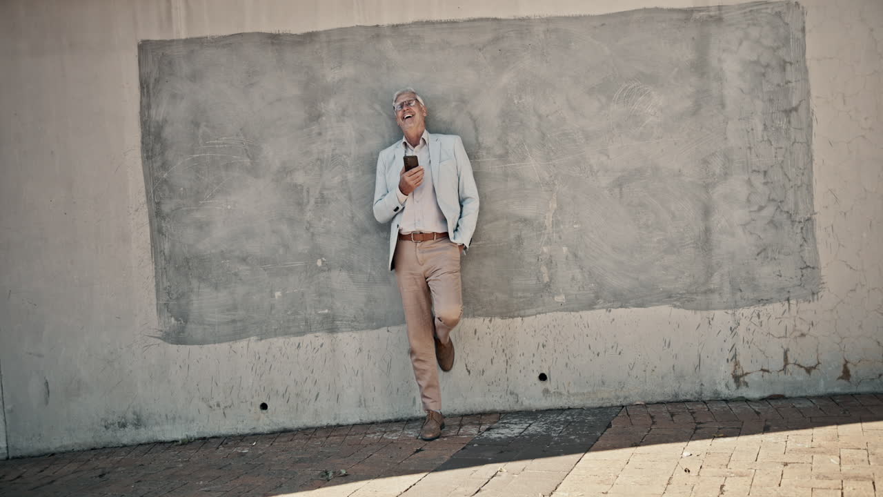 Man leaning against a concrete wall using a smartphone