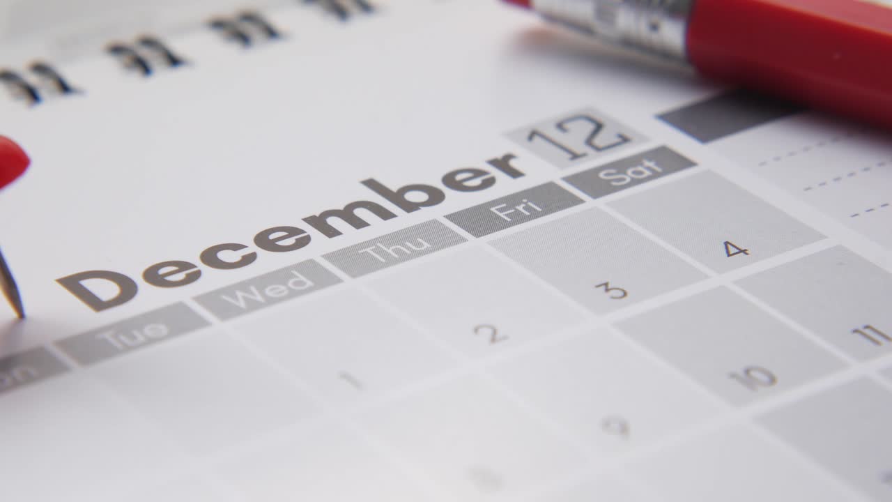 calendario de diciembre de 2023 con pluma roja y alfiler