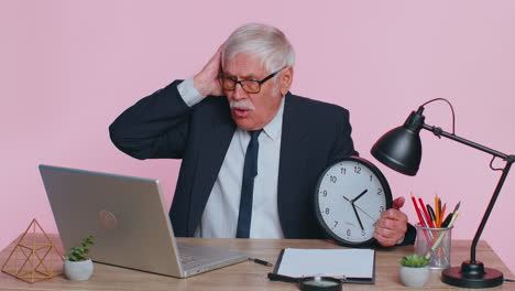 senior businessman with anxiety checking time on clock, running late to work being in delay deadline