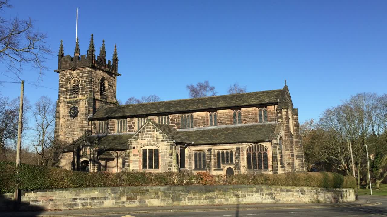 Bright winter exterior of St Bartholomew's Church in the town of Wilmslow, Cheshire, England. The church is recorded in the National Heritage List for England as a designated Grade I listed building.