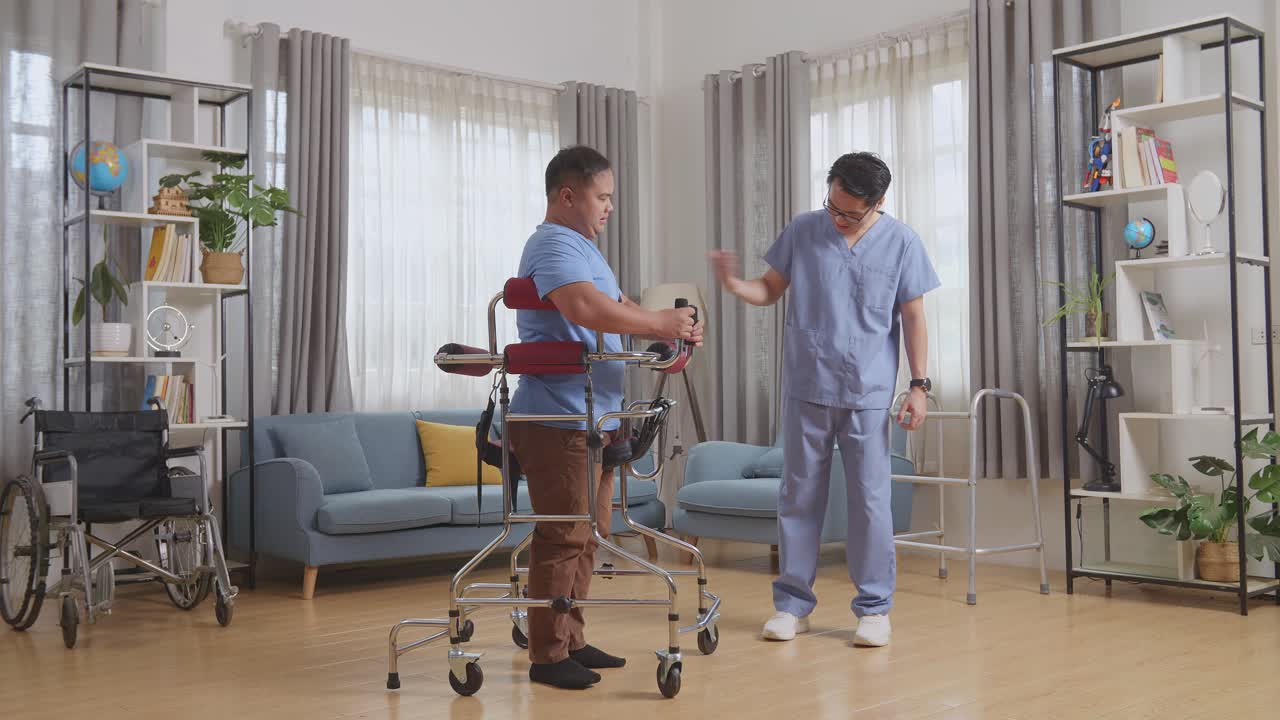 아시안 남성 간호사의 몸 전체 으로 볼 때, 손으로 손짓을 하고, 울고 있는 환자를 위로합니다. 집에서 물리 치료를 하는 동안 혼자 걸을 수 있는 보행기를 사용할 수 없습니다.