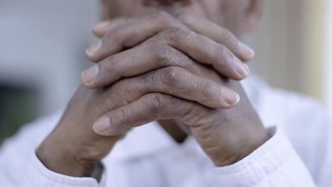 orando a dios con las manos juntas sobre fondo gris almacen de metraje de video