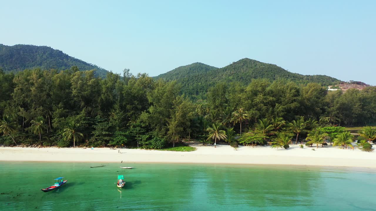 bahía de vacaciones tranquila con una tranquila laguna turquesa llena de barcos de pesca cerca de arena blanca de una playa exótica en la costa tropical de tailandia