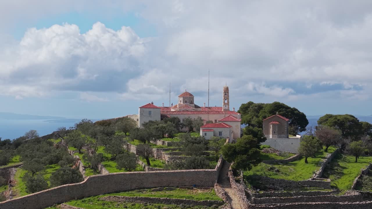 Ascending drone footage reveals the historic Prophet Elias Monastery atop Mount Eros on Hydra Island, offering sweeping panoramic views of the Aegean and surrounding landscape
