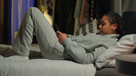 teenager using phone in bed