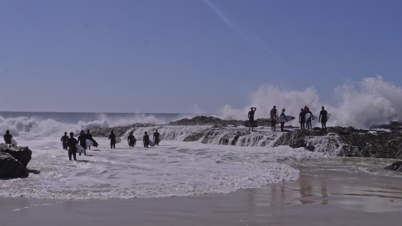 Surfers With Surfing Boards Watching Powerful Waves Breaking On Rock Formation At Snapper Rocks, QLD, Australia. wide shot