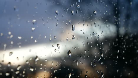 Gotas-De-Tormenta-Lluviosa,-Mal-Humor-Caen-Por-El-Cristal-De-La-Ventana-Closeup-Bokeh