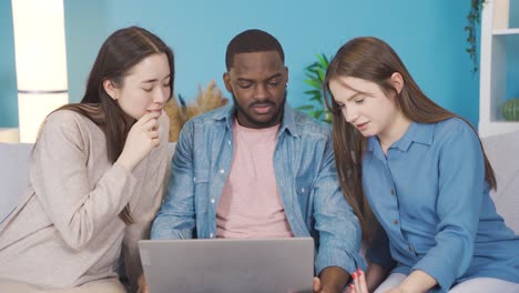 multiethnic group working on laptop at home.