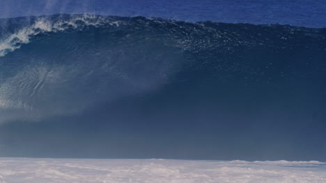 breaking wave spits ocean spray from crashing barrel in water, slow motion tracking