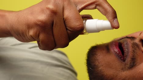 person applying mouth spray