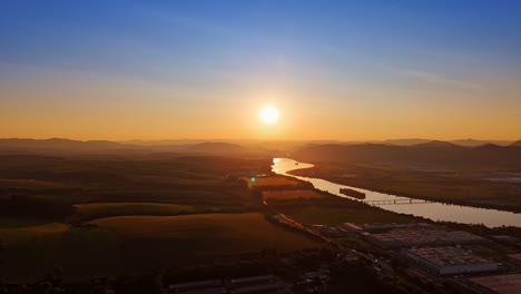 sunset over river valley landscape. vibrant sunset casts warm hues over river and fields, highlighting the natural beauty of the valley at dusk