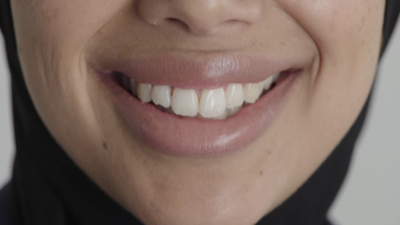 cerrar la boca de la mujer sonriendo satisfacción feliz mujer de oriente medio con hiyab dientes sanos