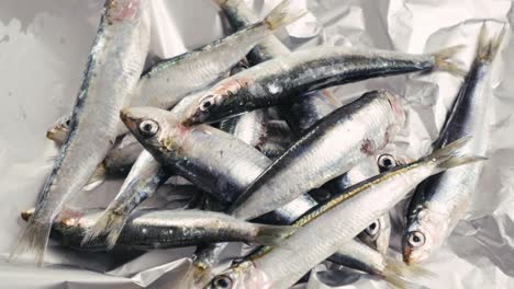 raw sardines on aluminum foil