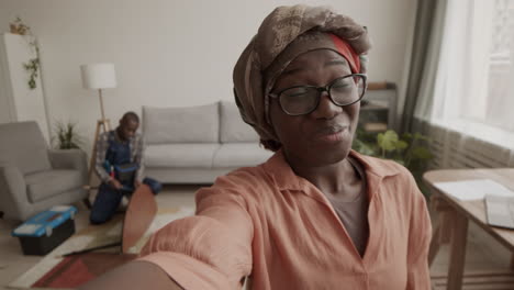 african-american woman shooting video while carpenter assembling furniture